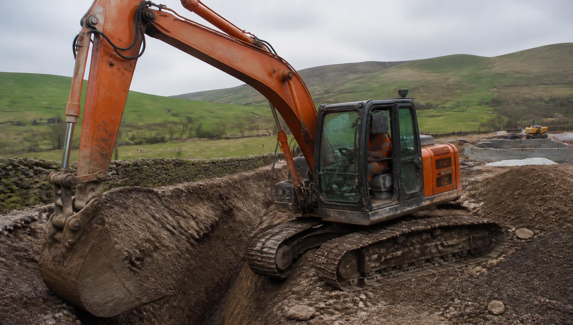 Excavator digging footings on a Lancashire groundworks site